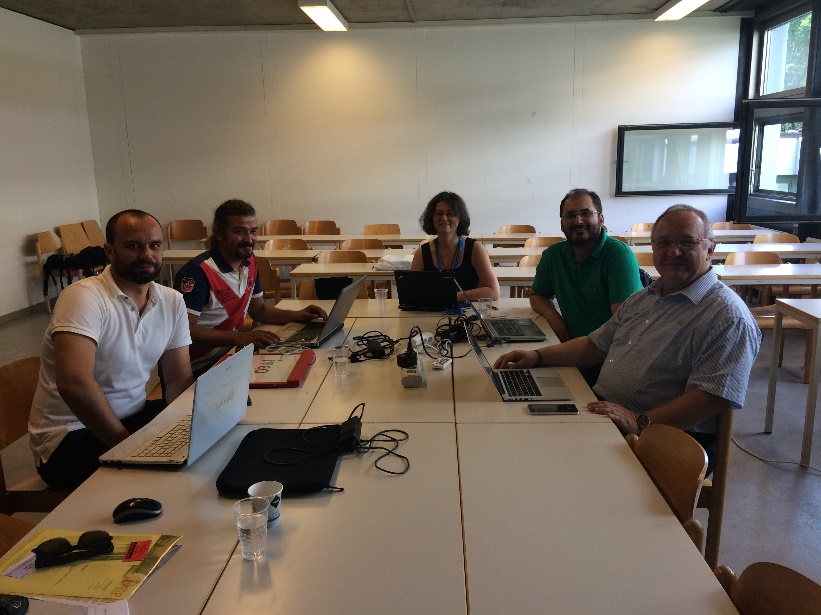 5 project members are sitting in a conference room around a table