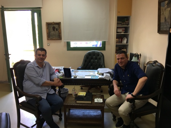 Two people are sitting in front of a desk in an office